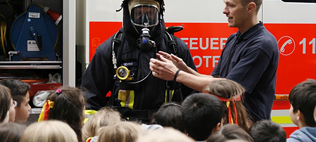 Wie sieht die Schutzausrüstung aus? Das lernen die Kinder bei ihrem Besuch bei der Feuerwehr
