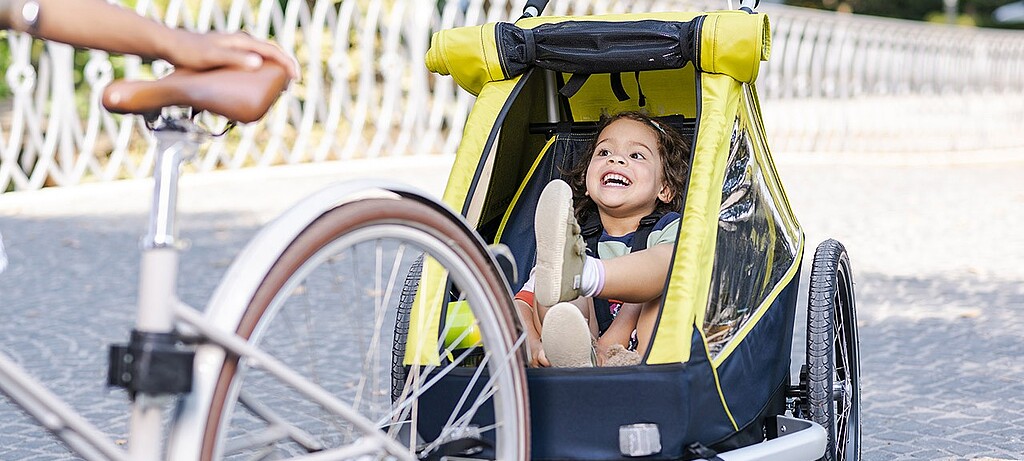 2019_0080_01 Im Fahrradanhänger sitzen Kinder komfortabel und können während der Fahrt sogar spielen oder schlafen